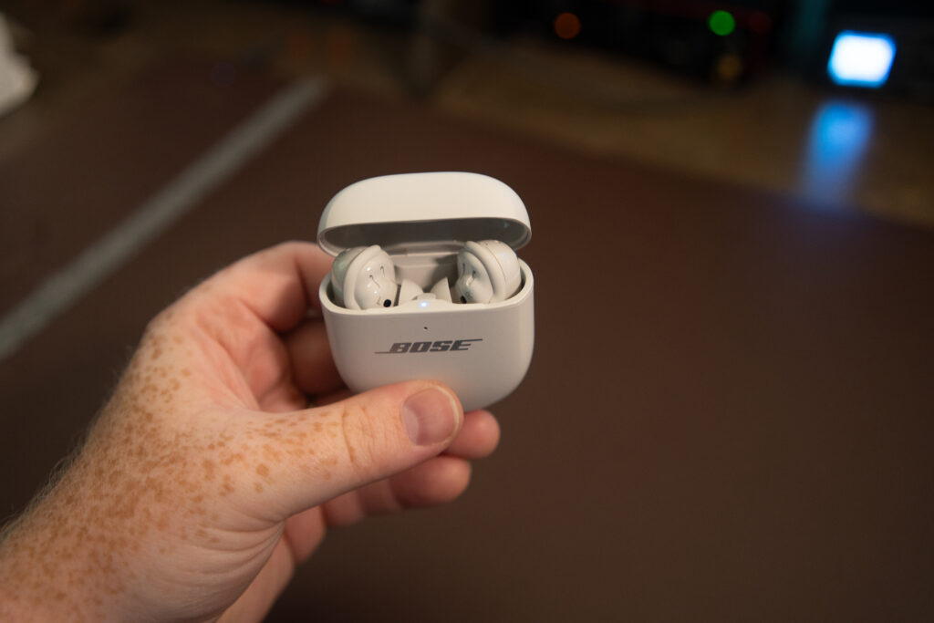 A hand holding the Bose QuietComfort Ultra Earbuds