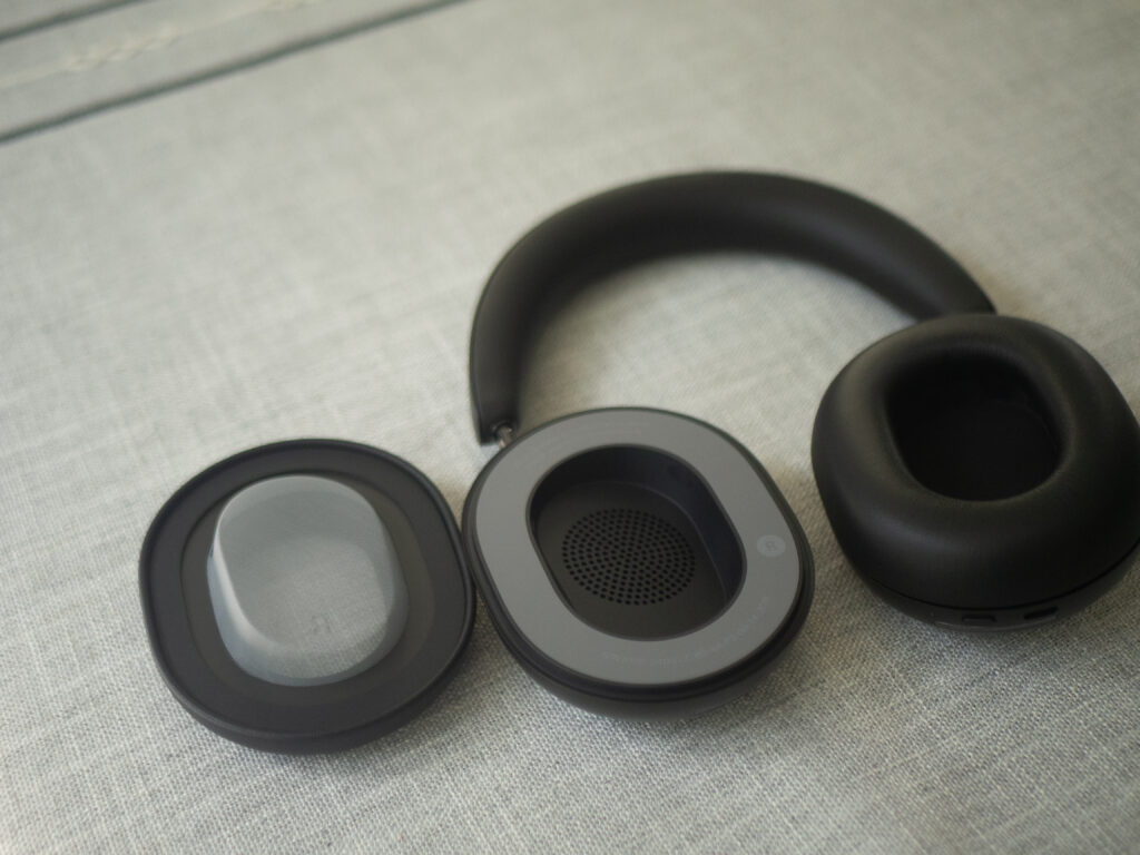 Sonos Ace headphones on a table face up with an ear pad pulled off and to the side